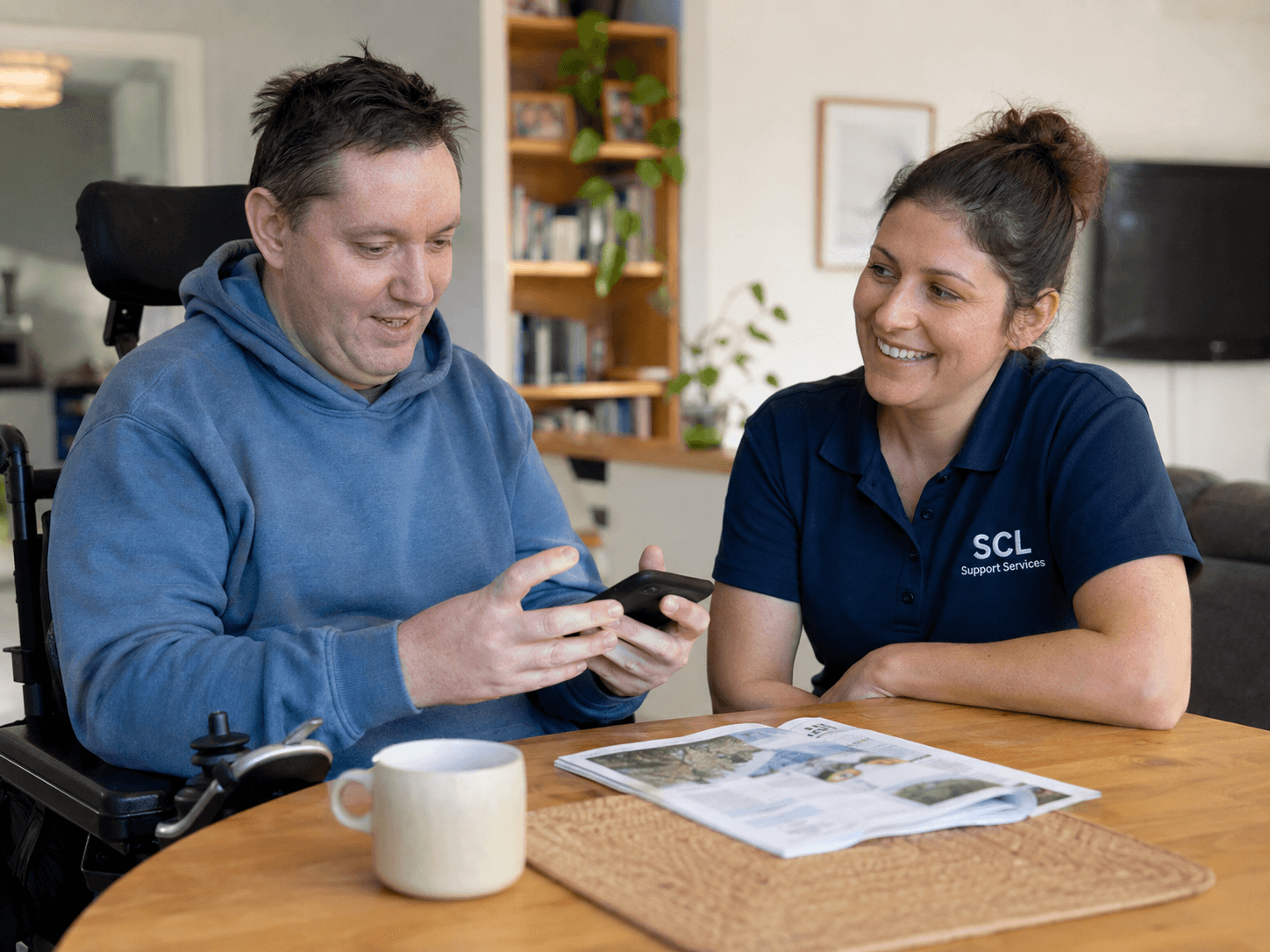A participant at home or in the community doing something ordinary, with support alongside rather than taking over.